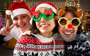 Trois personnes portant des lunettes de Noël avec des bois de renne et des couronnes