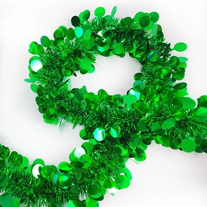 Detail of emerald green tinsel garland with shiny circular sequins for festive decoration