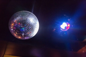 Detail of disco mirror ball with square glass facets and blue ambient light reflections