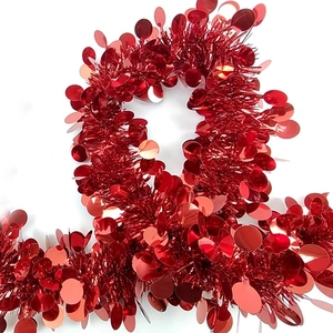 Detail of red festive tinsel garland with shiny round sequins for holiday party decoration
