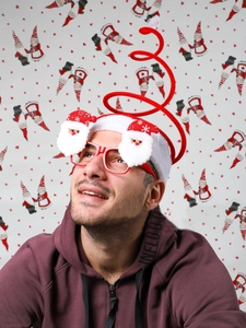 Close-up of a festive Christmas spring headband with Santa plush toys and red glasses