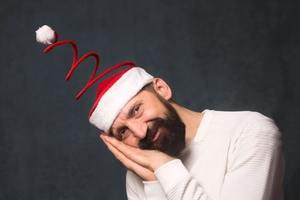 Funny red and white plush Christmas spring hat shown in a festive lifestyle photo