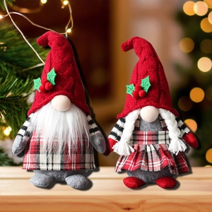 Pair of Christmas gnome plush dolls with leaf hats and knitted textures on festive wood
