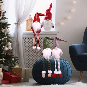 Detailed view of four Christmas gnomes with long legs and colorful hats in a cozy holiday setting