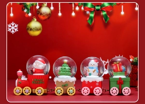 Macro view of four-carriage Christmas water globe train with Santa and snowmen figurines