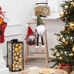 Close-up of long-legged Christmas gnome plush with festive holiday home decor scene