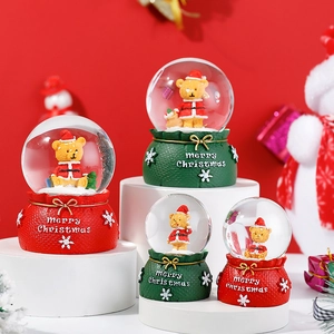 Close-up of Merry Christmas snow globes with bear figurines and festive red bases