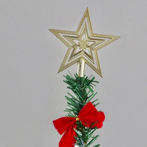Detailed view of golden 3D star tree topper with red velvet bow and green pine branch
