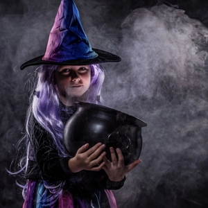 Girl's Halloween witch costume with gradient hat and purple wig in mystic smoke setting