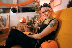 Steampunk goggles and gothic vest worn by a model in a Halloween pumpkin setting