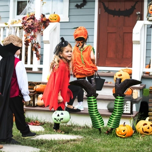 Detail of green and black striped witch legs with glitter boots for outdoor lawn decoration