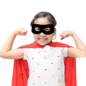 Close-up of children's superhero set with black felt eye mask and red star-print cape