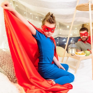 Kids superhero pajama set with a blue short sleeve suit, red cape, and matching eye mask