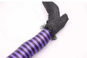 Macro detail of striped witch legs featuring purple fabric and black sequined boots