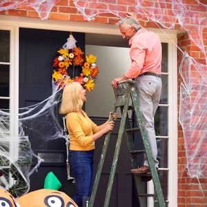 Realistic Halloween cobweb decoration with pumpkins and wreath on a home porch setup