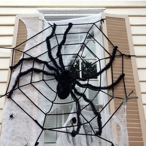 Outdoor Halloween decor with giant black plush spider and large rope spider web on window