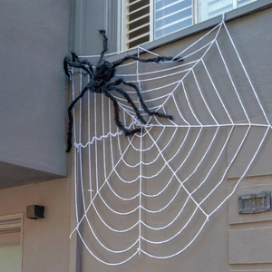 Close-up of a giant black fuzzy spider on a large white rope web for Halloween decor