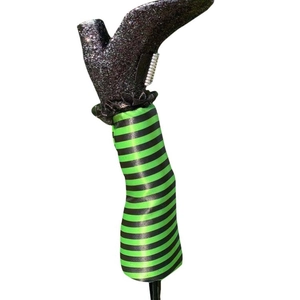 Halloween witch legs with black sequin boots and green striped stockings for yard decoration
