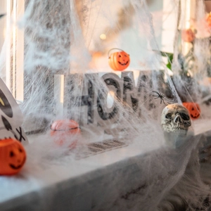 Detailed view of stretchable white spider web draped over home decor for Halloween setups