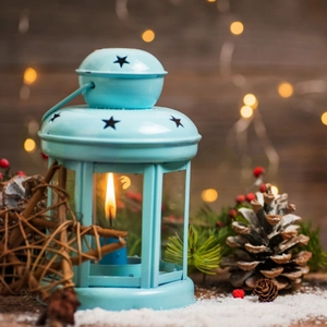 European hollow star lantern in light blue metal with pine cones and festive ornaments