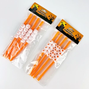 Detail of Halloween party straws set with white skull and ghost icons on orange tubes