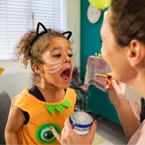 White face paint kit for Halloween cat makeup with fine detail brush and model girl