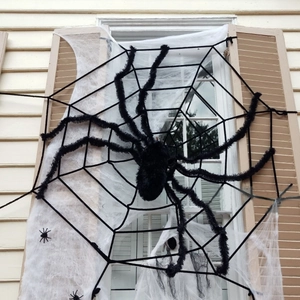 Large Halloween decoration featuring a giant black furry spider and a wide white spider web
