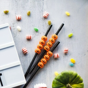 Halloween party straws with Jack-o'-lantern pumpkin ornaments on black flexible tubes