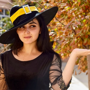 Detail of black witch hat with yellow velvet band and silver rhinestone buckle decoration