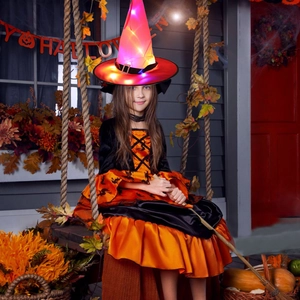 Close-up of LED glowing witch hat and bat pattern dress for Halloween party decorations