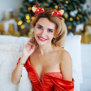 Detail shot of cute reindeer antler hair clips with red bows and bells on a model