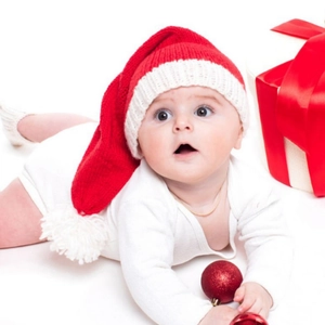 Winter knitted baby Christmas outfit with long tail hat and white romper on white backdrop