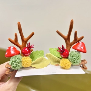 Close-up of reindeer antler hair clips with red mushrooms and berries for Christmas