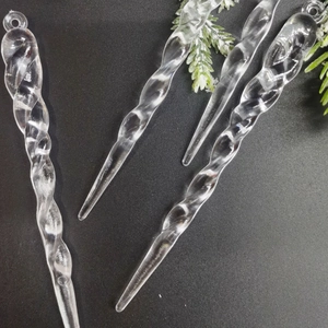 Macro shot of 4 clear twisted icicle Christmas tree ornaments on a black background