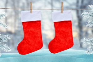 Calze di Natale classiche in peluche rosso con bordo bianco appese in una foresta innevata