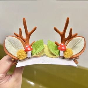 Detail shot of brown flocked reindeer antlers hair clips with felt leaves and mushrooms