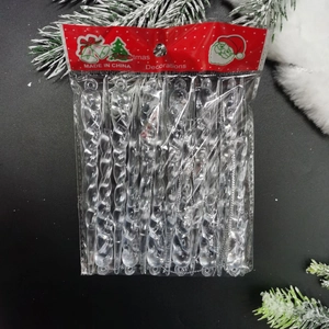 Clear acrylic Christmas icicle ornaments in festive packaging with snowy pine needles