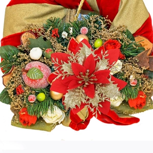 Detail of Christmas poinsettia decoration with red berries, pine needles and gold ornaments