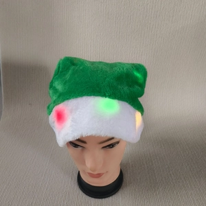 Détail d'un bonnet de Noël lumineux avec des lumières LED colorées sur un tissu en peluche vert