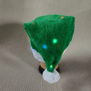 Détail du bonnet de Noël en peluche verte avec lumières LED sur un support de tête