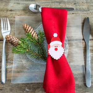 Detail of Santa Claus napkin ring holder with felt textures on festive table setting