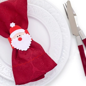Santa Claus felt napkin ring set with red jacquard napkin on white ceramic plate