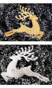 Detailed view of leaping Christmas reindeer hanging ornaments in gold and silver finish