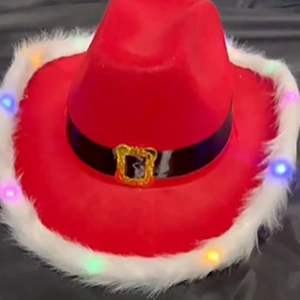 Detail of red Christmas cowboy hat with LED lights, white faux fur trim and gold buckle