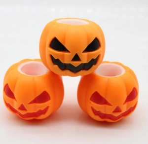 Macro detail of orange pumpkin beads with spooky jack-o'-lantern faces for DIY jewelry