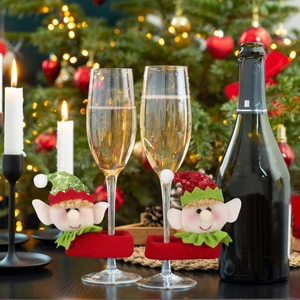 Detail of sequined elf wine glass charms on stemware for Christmas party table decor