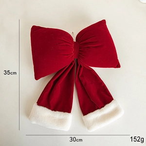 Detail view of large red velvet Christmas bow with white fur trim and size measurements