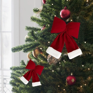 Detail of red velvet Christmas bows with white faux fur trim on a decorated tree