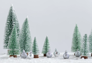 Miniature cedar Christmas trees with snow effect and silver ornaments on wood base