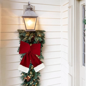 Large burgundy velvet Christmas bow with white plush trim on a festive holiday wreath